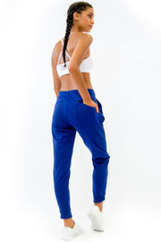 Back of Rare Active modern tearaway pants for women in deep blue.