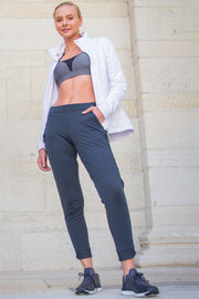Model wearing Rare Active modern tearaway pants for women in charcoal grey. 